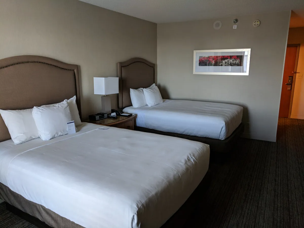Two separate beds in an illustrative hotel room